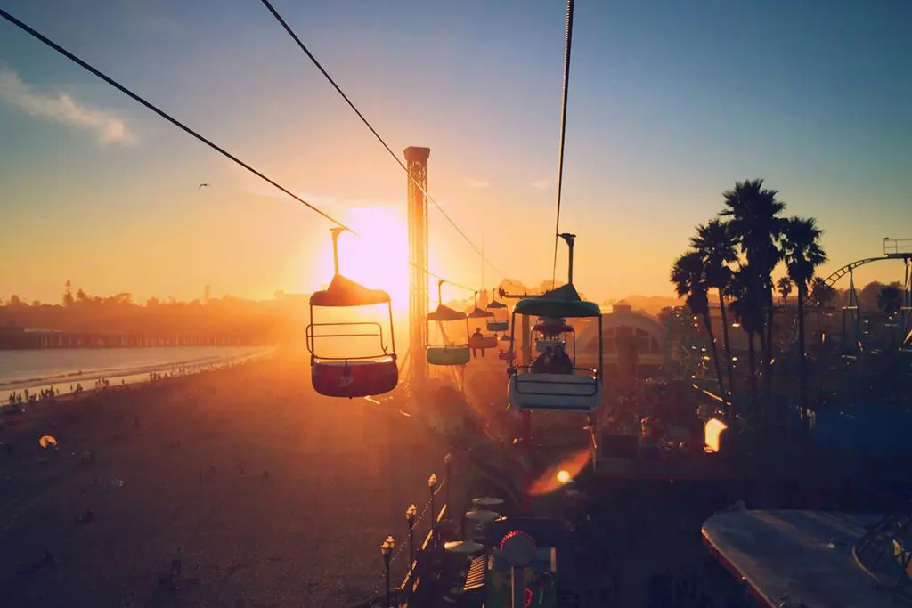 Visitors enjoy a amusement ride during sunset on a day trip to the Santa Cruz wharf.