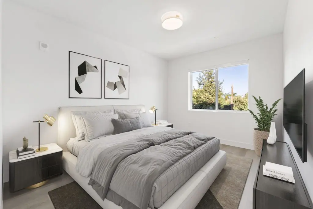 Modern apartment bedroom with layered lighting at The Deck apartment community.
