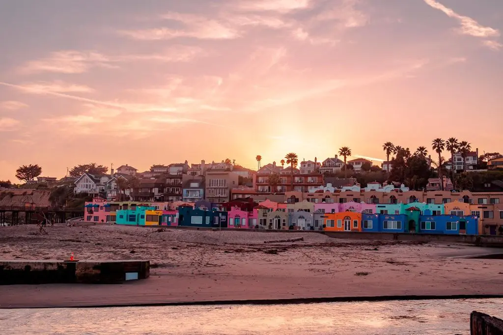 Colorful Venetian Court beachfront buildings overlooking Capitola Beach at sunset in Capitola, California.