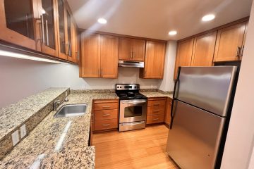 Kitchen with brown cabinets & stainless steel appliances.