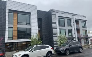 Nexus on 9th building exterior view from the street with cars parked in front.