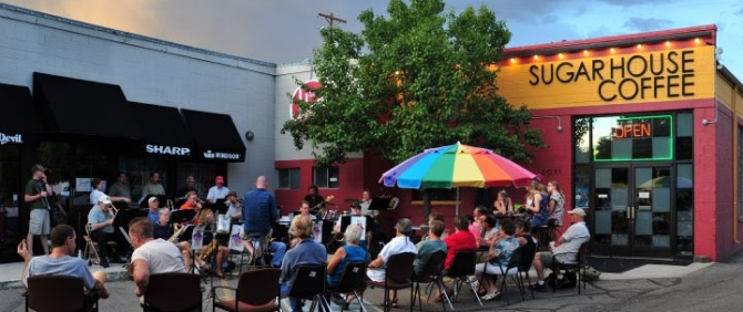 Live band performing for an audience in front of Sugar House Coffee.