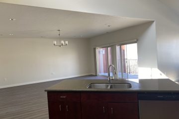 Open floor kitchen & dining room with glass sliding doors to patio balcony.