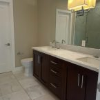 Bathroom with dark cabinets and tile floors.