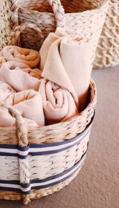 Towels in a basket as apartment decor idea for the bathroom.